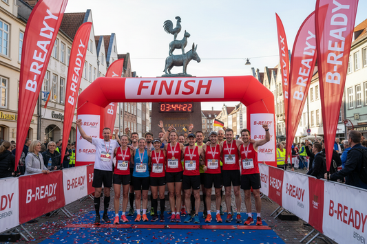 Teilnehmer stehen vor den stadtmusikanten in zielliene überall B-READY Banners auf einem event